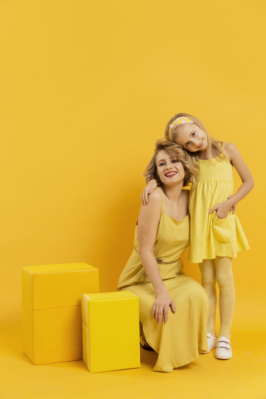 Dia das Mães 2024 no mercado da moda: mãe e filha vestidas de amarelo em um fundo amarelo.