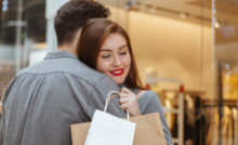 Casal em frente a vitrine de loja de roupas